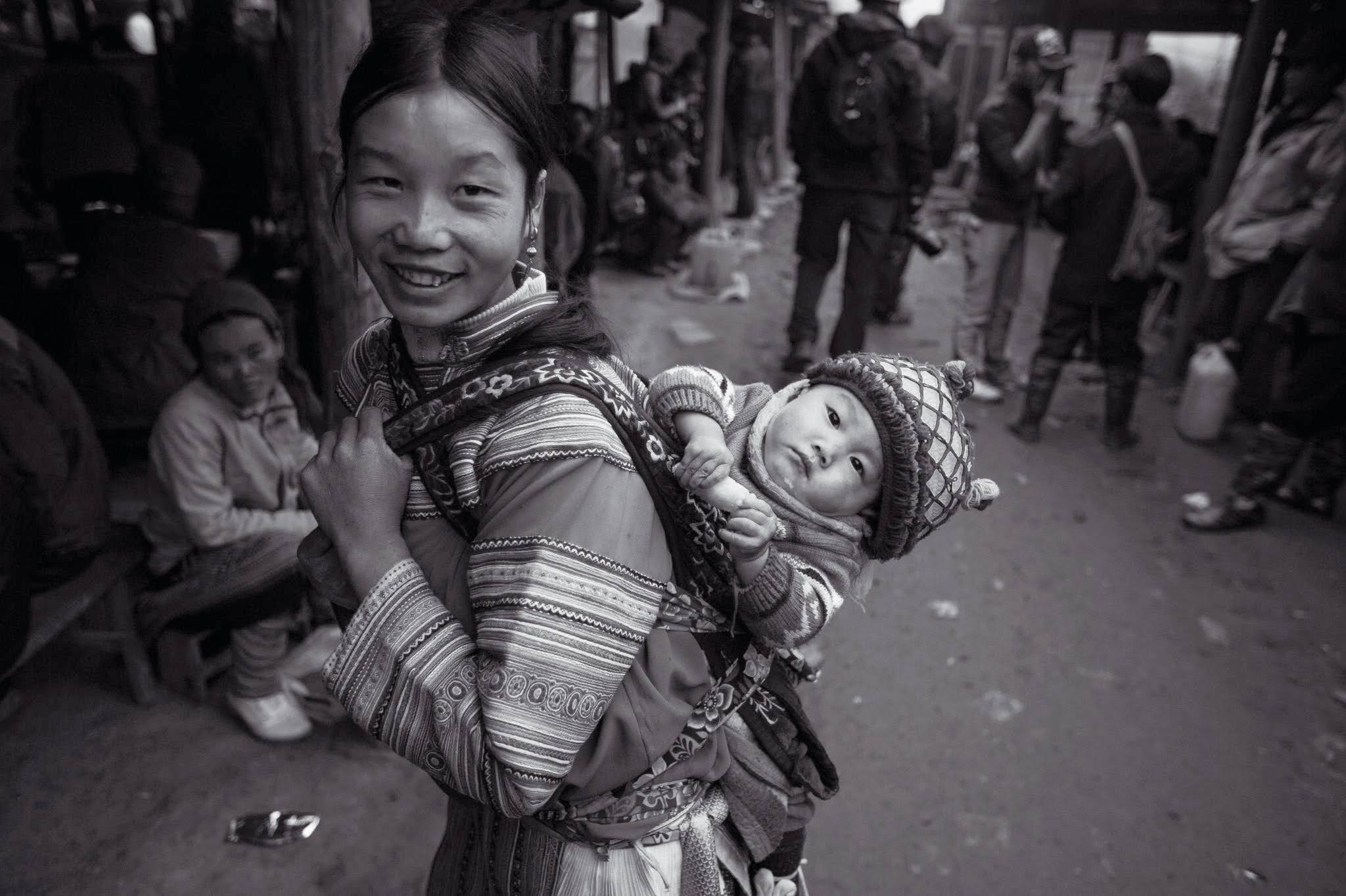 Woman carrying child at market